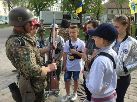 ウクライナの兵士が子どもたちに銃について教えている。Photo credit: Yandex