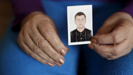 ウクライナでの家宅捜索で遺体の一部が見つかったオレクサンドル・フロロフの写真を手にする親族。
