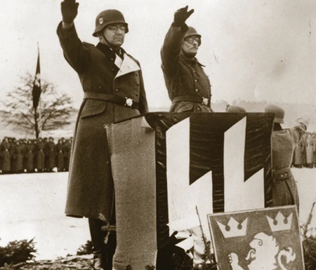 ユダヤ人の大量殺戮に直接関与した狂信的なナチス、フリッツ・フライターク武装親衛隊の准将（左）は、新たに編成された第14 SSガリシア師団から敬礼を受けている。咆哮するライオンのマークが再び登場する。Photo credit: EspiritDeCorps