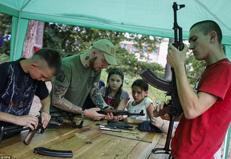 アゾヴェツの子どもたちは、自動小銃の組み立てと分解を学んでいる。Photo credit: DailyMail