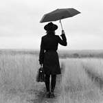 草原で女性が傘をさしている